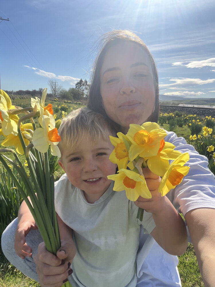 Victoria with her son, picking daffodils.